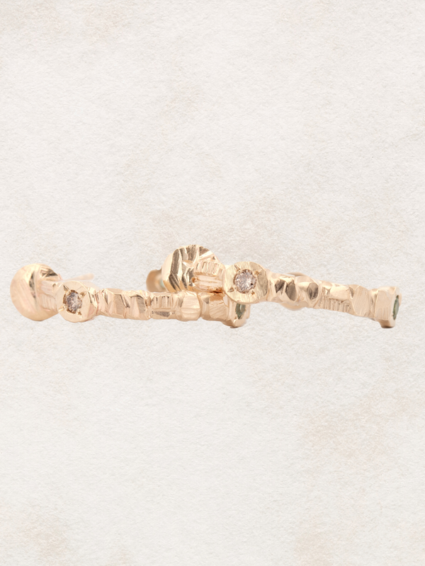 Gold ring with diamond accents on a light beige background